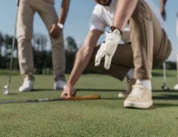 A group of men watch a putt