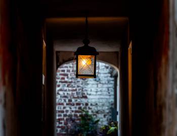 lit lantern in old paved alleyway