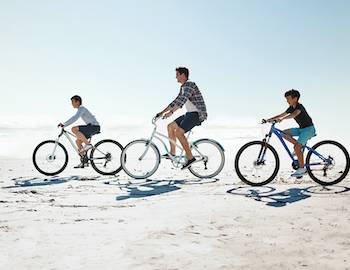 family biking on beach