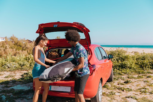 A family loading beach chairs, coolers, and suitcases into an SUV outside a Kiawah Island vacation rental